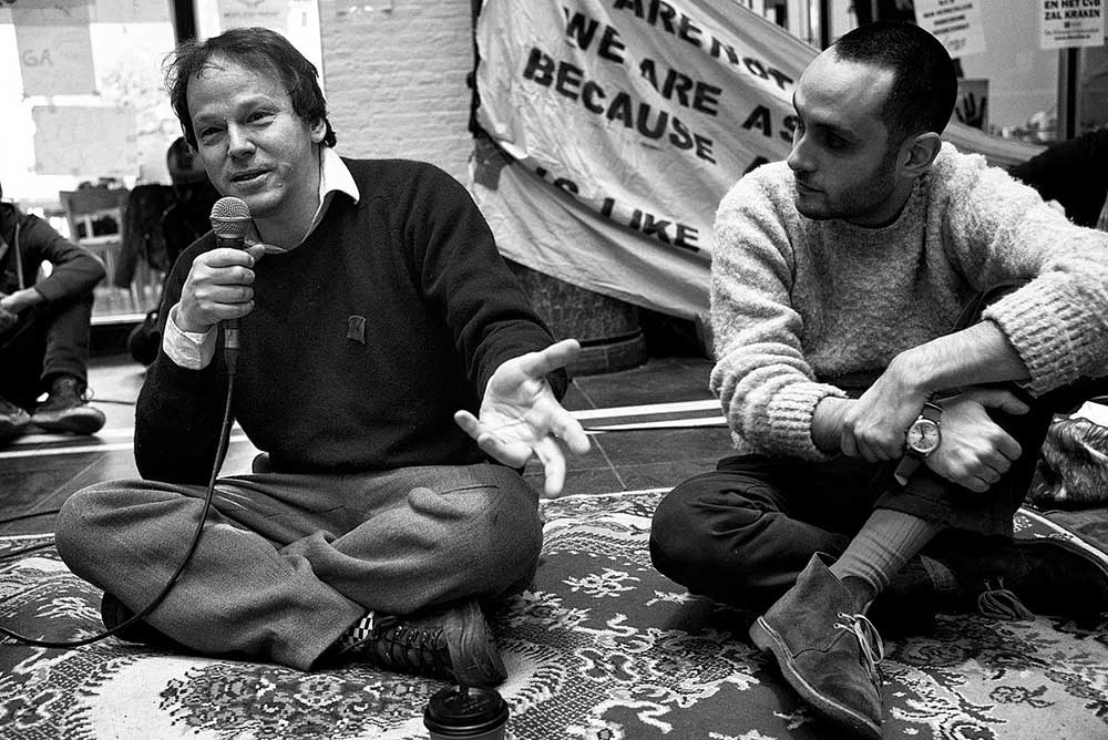 Photo of David Graeber speaking in front of a crowd at Occupy