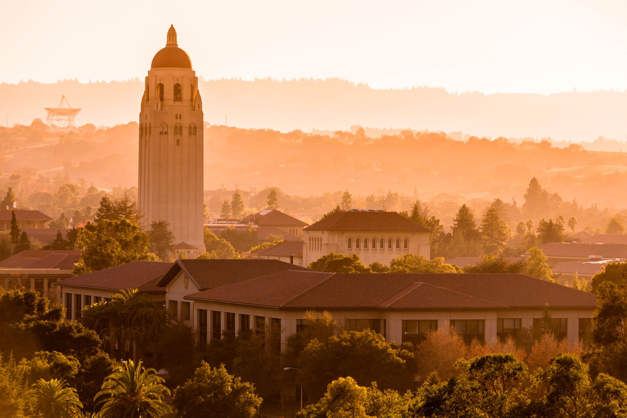 A sepia-tone photo of Stanford University campus, showing the conservative Hoover Institution tower and the radar dish built by the United States Air Force